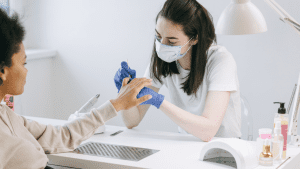 nail technician doing nails on a client 