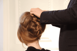 A person braiding someone's hair 