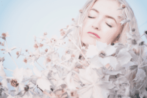 A woman with white hair covered in white leaves