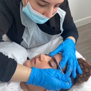 student mapping eyebrows on microblading course