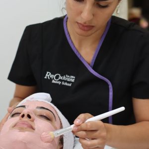 student applying face mask on model