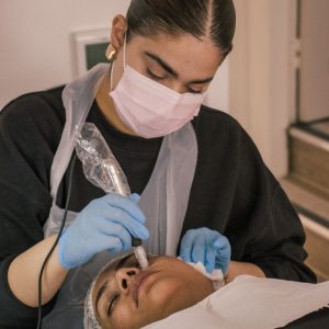 student practicing microneedling on face