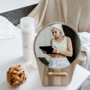 woman looking at ipad, wearing undereye mask